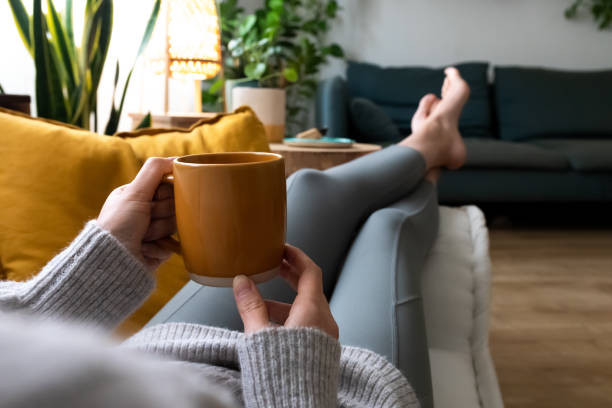 Mujer relajada en el sofá tomando un café